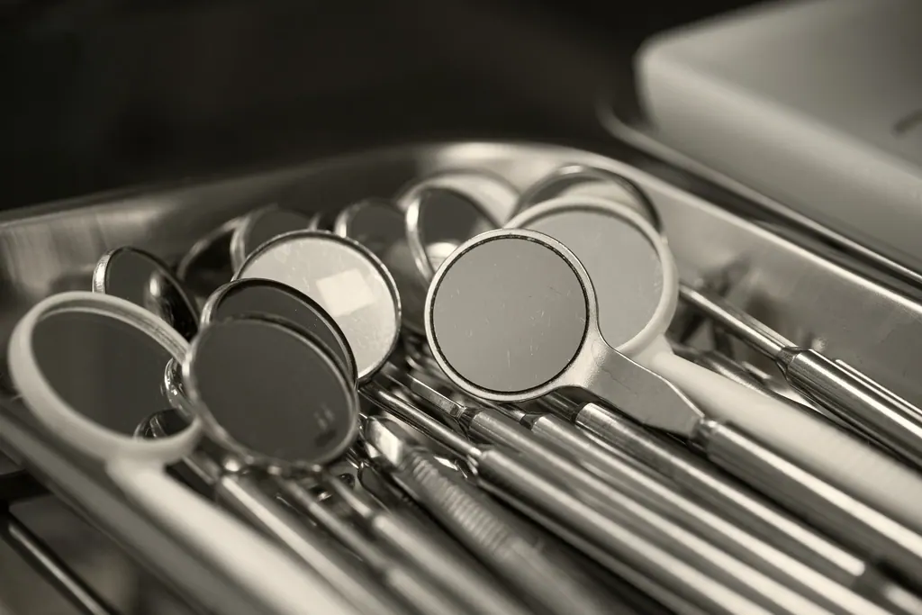 Espelhos clínicos e instrumentos de aço organizados em uma bandeja.